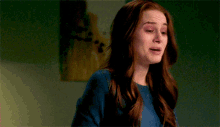 a woman with red hair is crying in front of a painting .