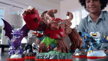 a group of toy figures are sitting on a table including a dragon