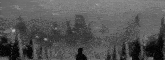 a black and white photo of a man standing in the snow in front of a giant owl .