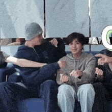 a group of people are sitting on a couch playing a game .