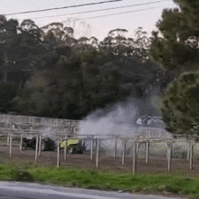 a car is driving down a road with smoke coming out of the hood .