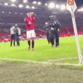a soccer player wearing a red jersey that says vodafone on it