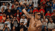 a shirtless wrestler is giving a thumbs up in front of a crowd with the hashtag thekamdreesen