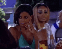 a group of women are sitting at a table with wine glasses and talking to each other .