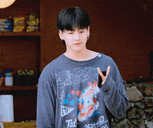 a young man wearing a t-shirt that says mr. todd giving a peace sign