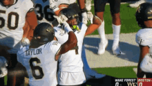 a football player named taylor is hugging another player on the field