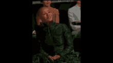 a woman with a shaved head is sitting in a theatre .