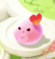 a pink object with a heart on top of it is on a plate .
