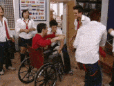 a man in a wheelchair is surrounded by people