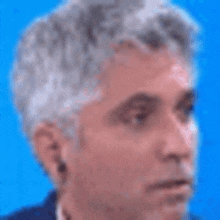 a close up of a man 's face with a blue background