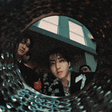 a group of young men are looking through a mirror