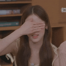 a woman covering her face with her hand while smiling