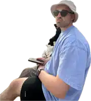 a man wearing a hat and sunglasses holds a cellphone