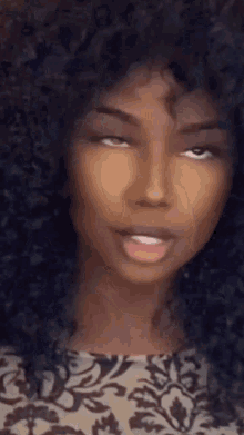 a close up of a woman 's face with curly hair making a funny face .