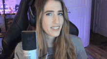 a woman wearing headphones is sitting in front of a microphone .