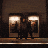 a group of men are dancing in front of a wall with a picture of a man on it
