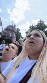 a woman and a boy are looking up at something in the sky