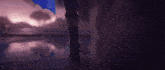 a person is holding a sword in a dark room with a blue light behind them .