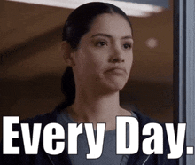 a woman is standing in front of a sign that says " every day " .
