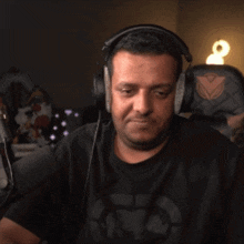 a man wearing headphones is sitting in a chair with a triangle on the back of it
