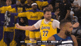 a basketball player wearing a lakers jersey stands in front of a crowd