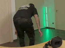 a man with a tattoo on his arm is wearing a black t-shirt that says ' samurai ' on the back