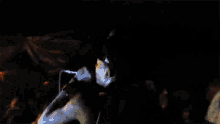 a man sings into a microphone in a dark room