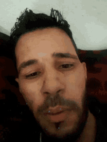 a close up of a man 's face with a beard and curly hair