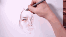 a person is drawing a woman 's face with pencils