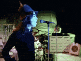 a man singing into a microphone while wearing a white hat