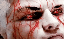 a close up of a person 's face with blood coming out of their eyes .