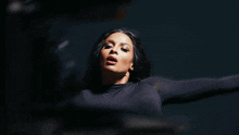 a woman in a black dress is pointing her finger