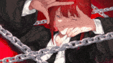 a girl with red hair is surrounded by chains and covering her face with her hands