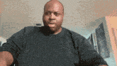 a man wearing a black shirt looks at the camera