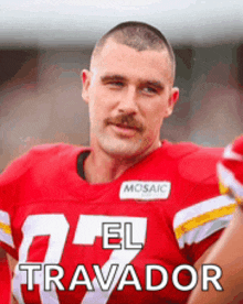 a man with a mustache wearing a red jersey that says travador