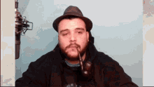 a man with a beard wearing a hat and smoking a pipe