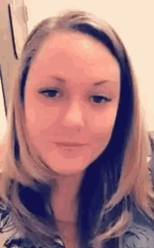 a close up of a woman 's face with long hair and a serious look on her face .