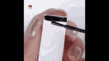 a close up of a person applying mascara to a piece of paper .