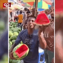 a man is holding a sliced watermelon in front of a crowd of people