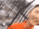 a woman in an orange shirt is taking a selfie in front of a building