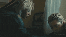 two women are looking at a computer screen with thunderbolts on the bottom right