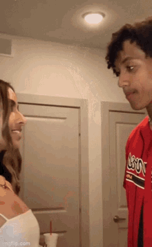 a man and woman are looking at each other in a room .