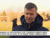 a man in a hooded jacket is talking about the fifa world cup in canada