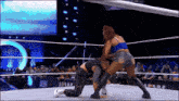 two women are wrestling in a wrestling ring with a crowd watching