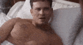 a shirtless man is laying in a hospital bed with a tattoo on his chest