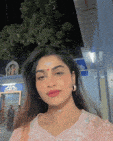 a woman with a red dot on her forehead looks at the camera