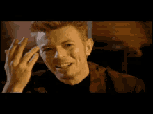 a close up of a man laughing with his hands in the air