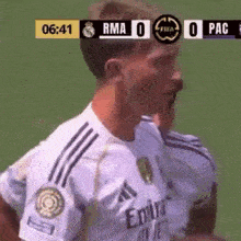 a soccer player wearing a white jersey with emirates written on it is standing on a field .