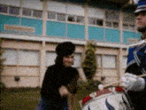 a man in a blue uniform is playing a drum in front of a woman in a black top