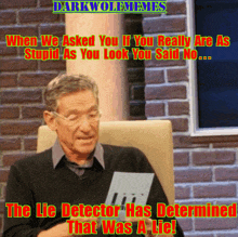 a man sitting in front of a brick wall holding a piece of paper that says lit